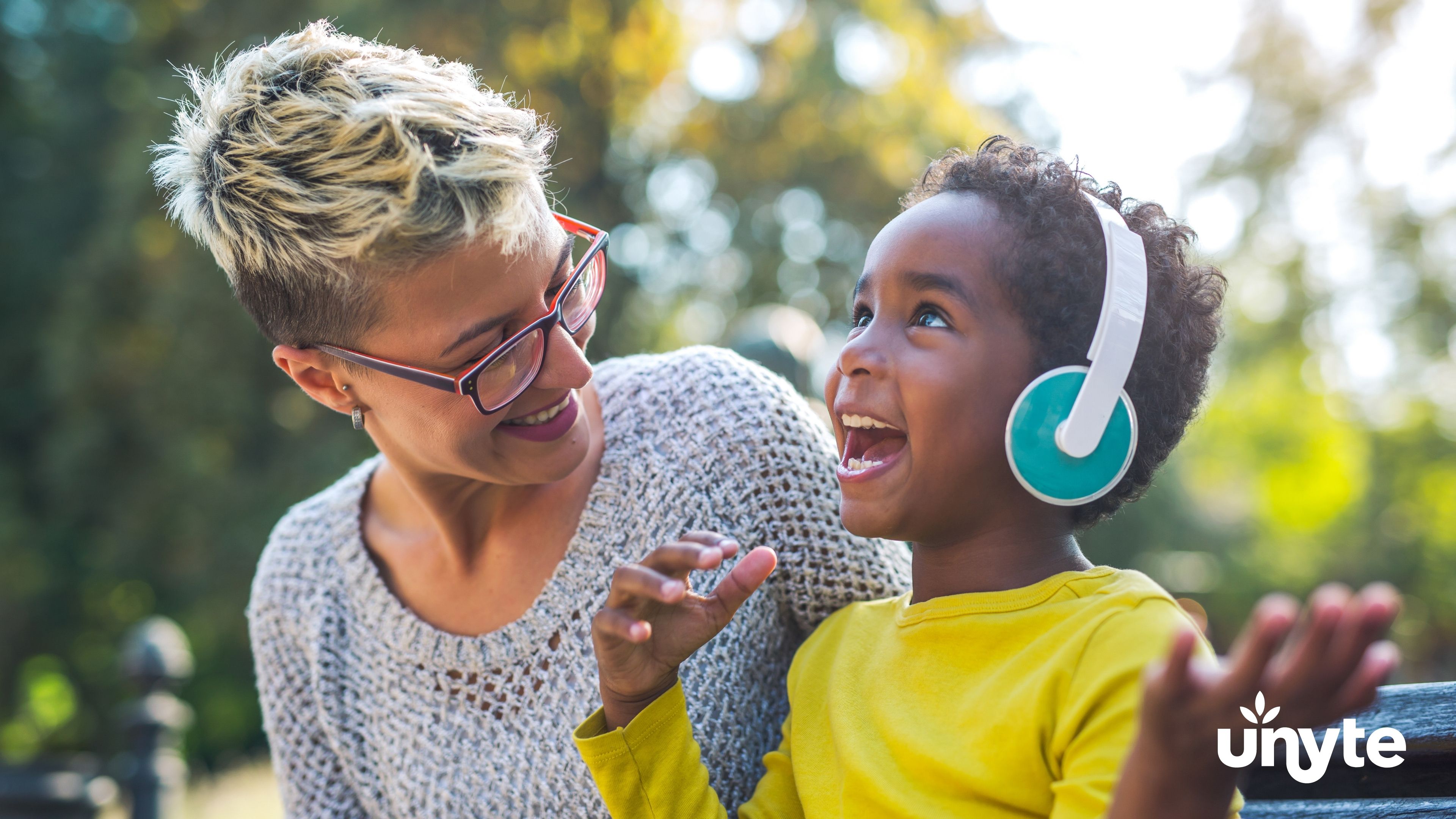 Woman and child laughing together with headphones during SSP session